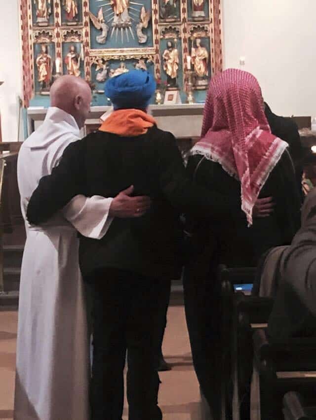 A Christian, Muslim and Sikh share a hug at St James Church, Hebden. Credit: Rachel Brandwood